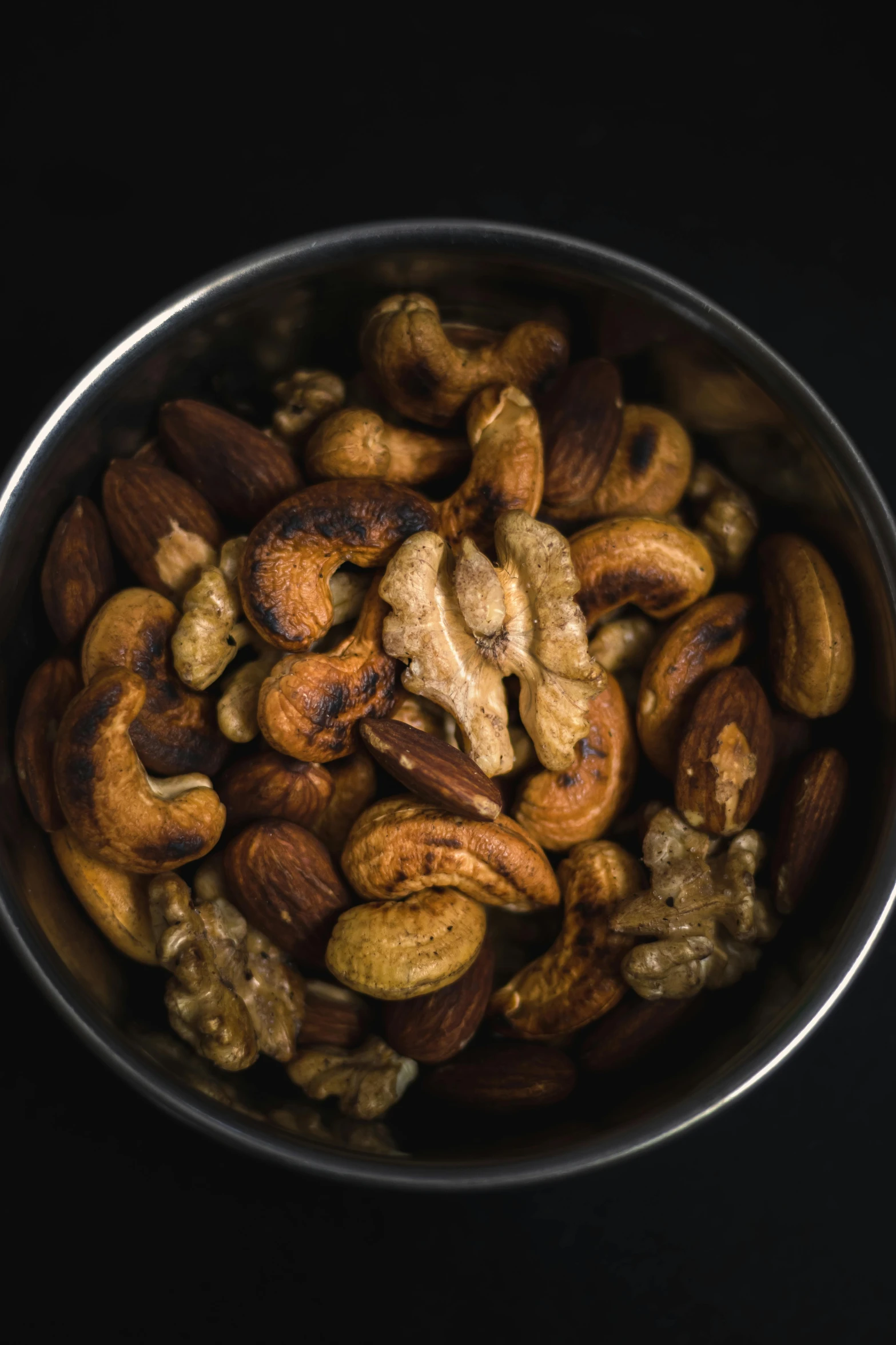 a bowl full of mixed nuts on top of a counter