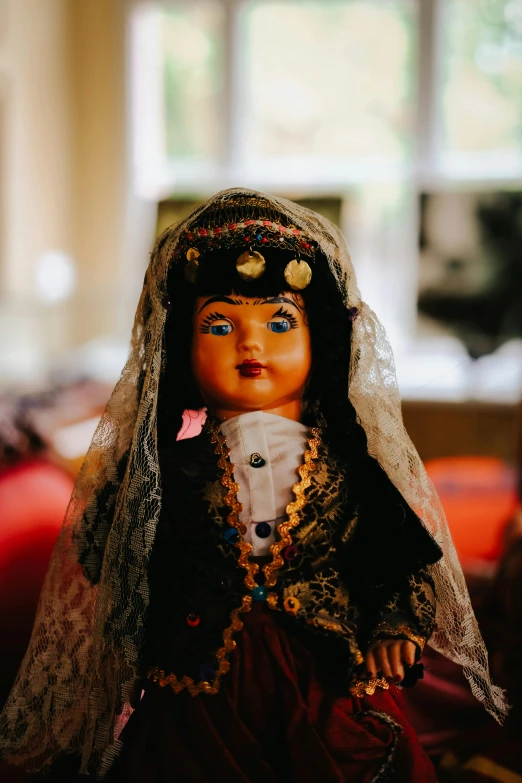 a doll with a veil and dress has an animal on its forehead