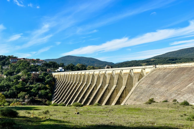 a train traveling past a dam surrounded by mountains