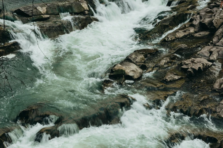 there are rocks on the water that are running down them