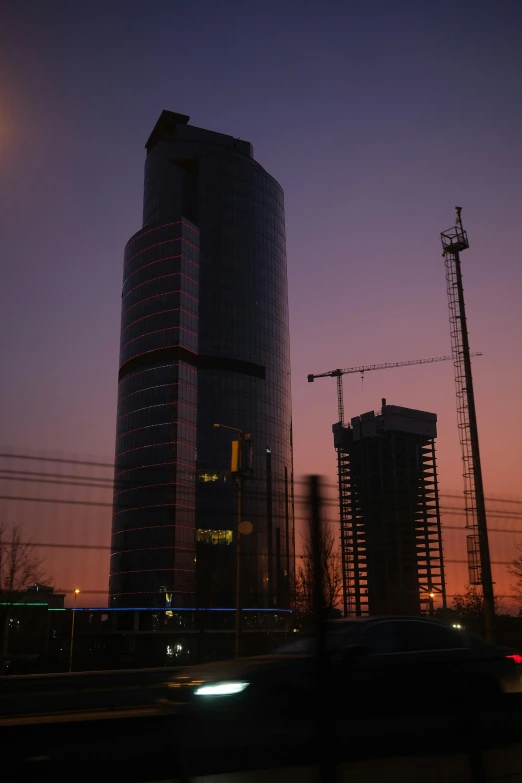 car passing under construction in front of a tall building