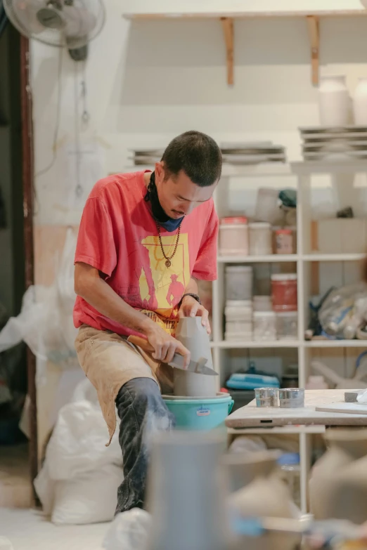 a man in red shirt pouring water from bottle