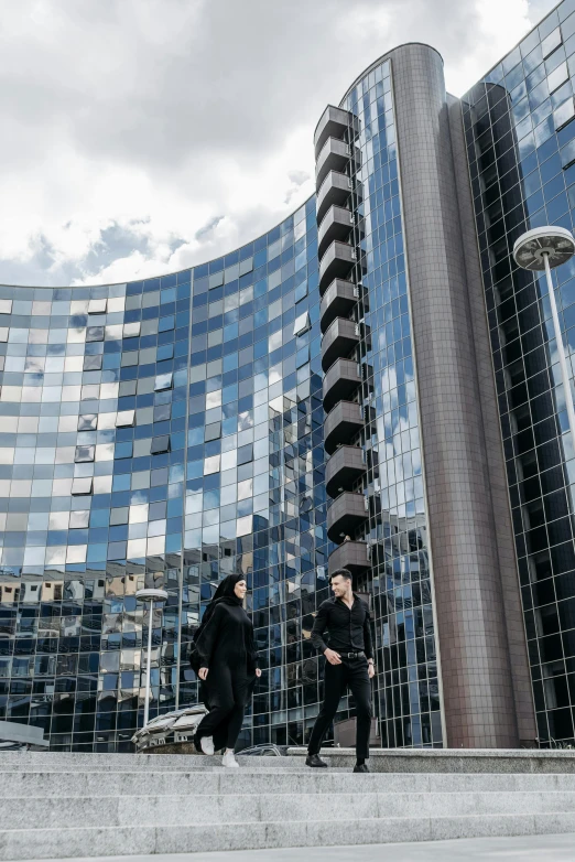 two people walking up the stairs towards some tall buildings