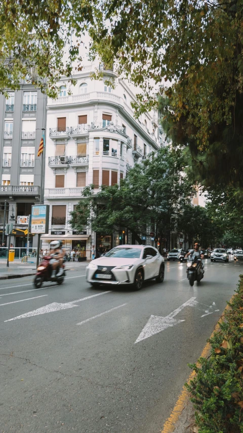 some cars and motorcycles are driving down the street