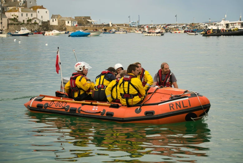 an orange raft with five people wearing life jackets