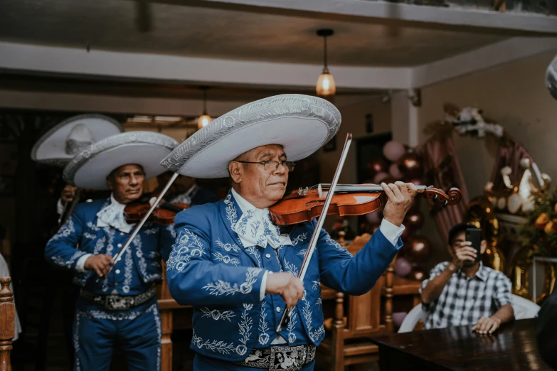 men in blue shirts playing instruments and people in hats