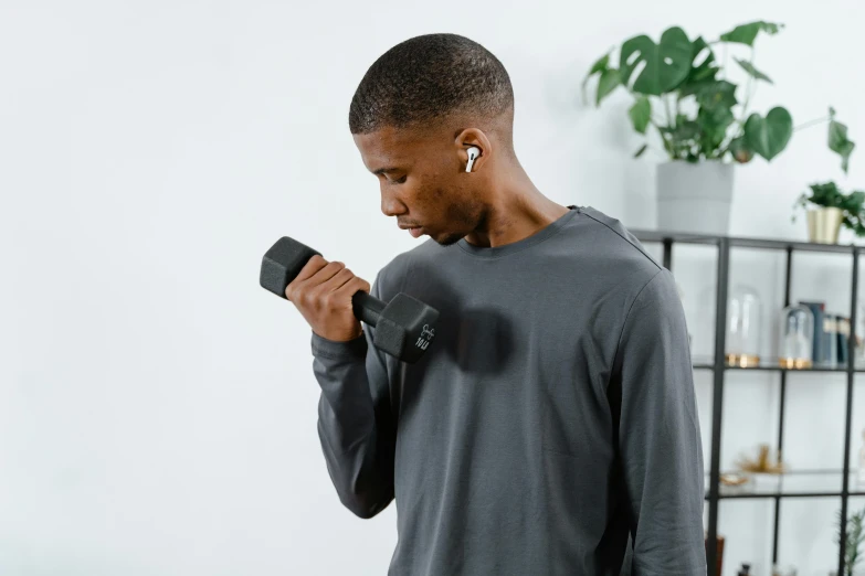 a man wearing ear buds stands near a shelf