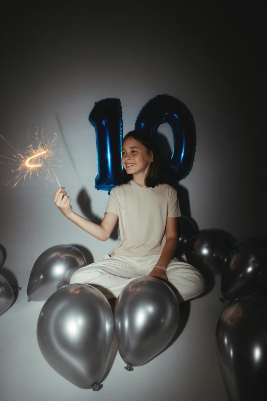 a woman holding onto some balloons and a number 90