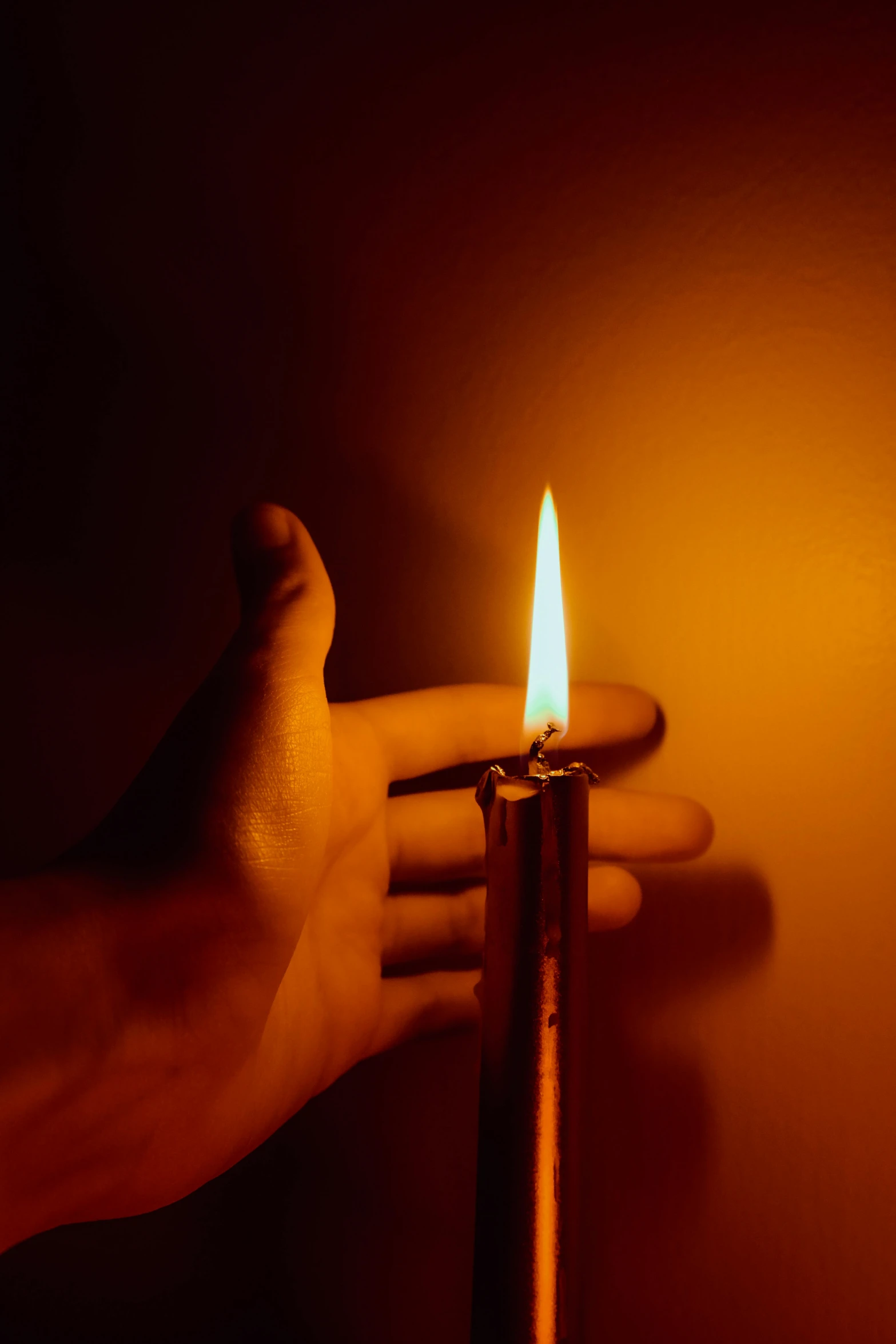 two hand holding a lighter while standing in front of a wall