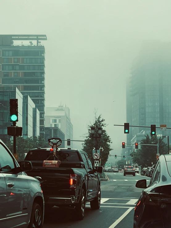 cars are at an intersection, surrounded by skyscrs