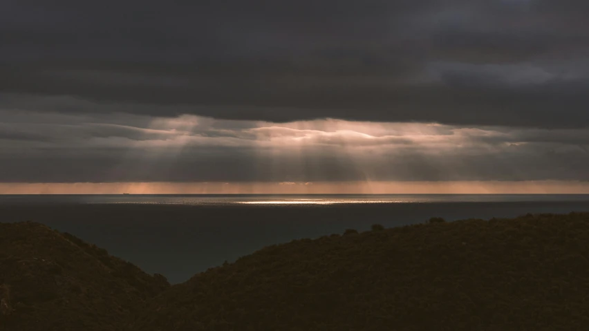 a cloudy night with sunbeams coming from behind it