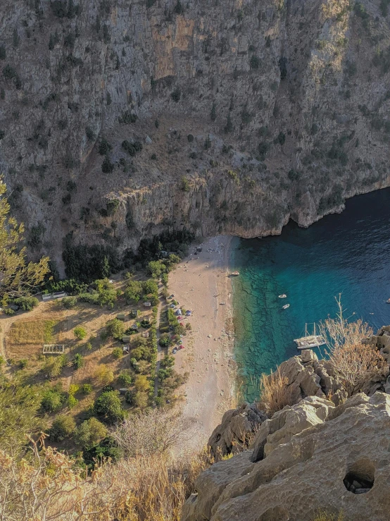 a rocky beach is shown with boats in the water