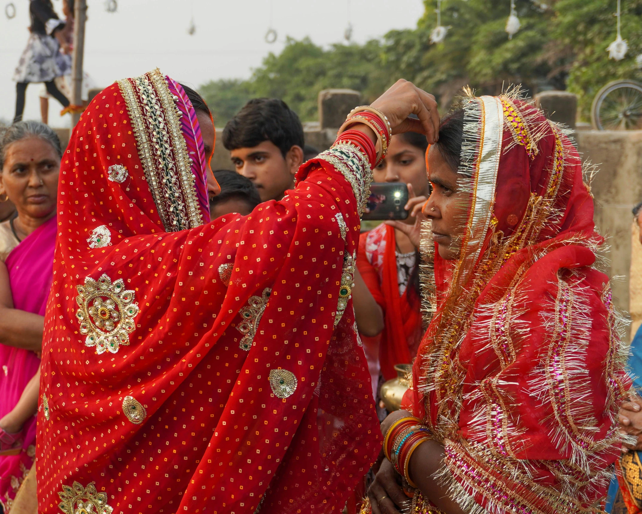 men and women wearing red sari around their necks