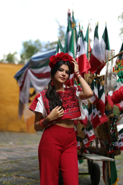 a girl in mexican clothes next to many flags