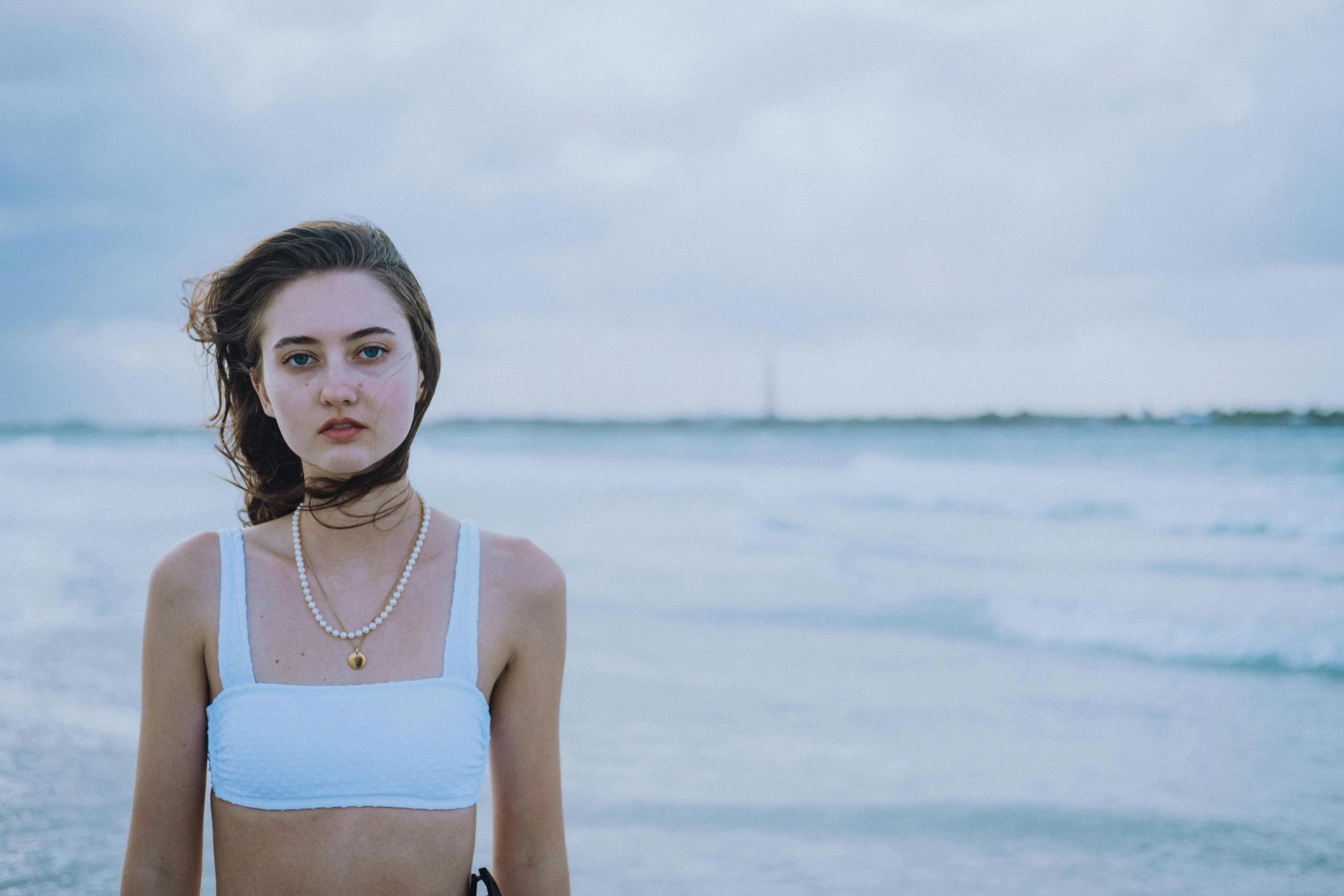 a woman is standing in the water at the beach