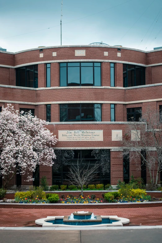 a courtyard with a fountain and brick building