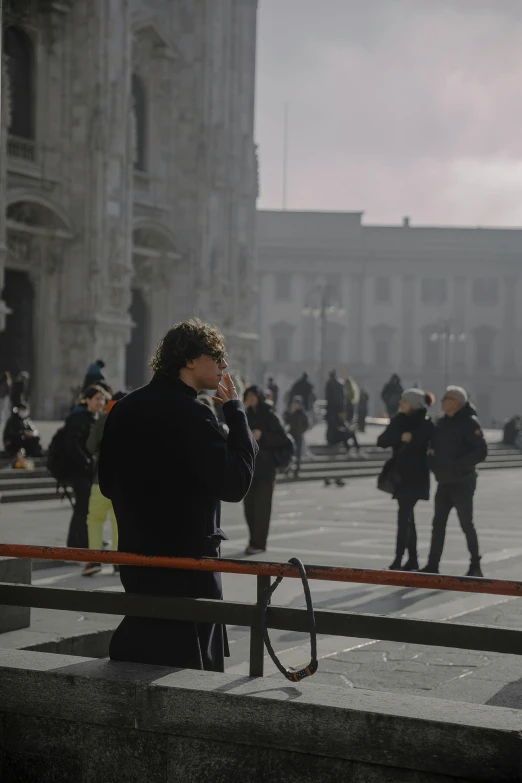 the man in the black coat is talking on his cellphone