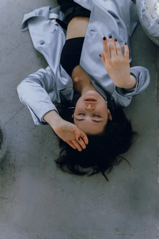 a young woman is laying on the floor with her hands in her hair