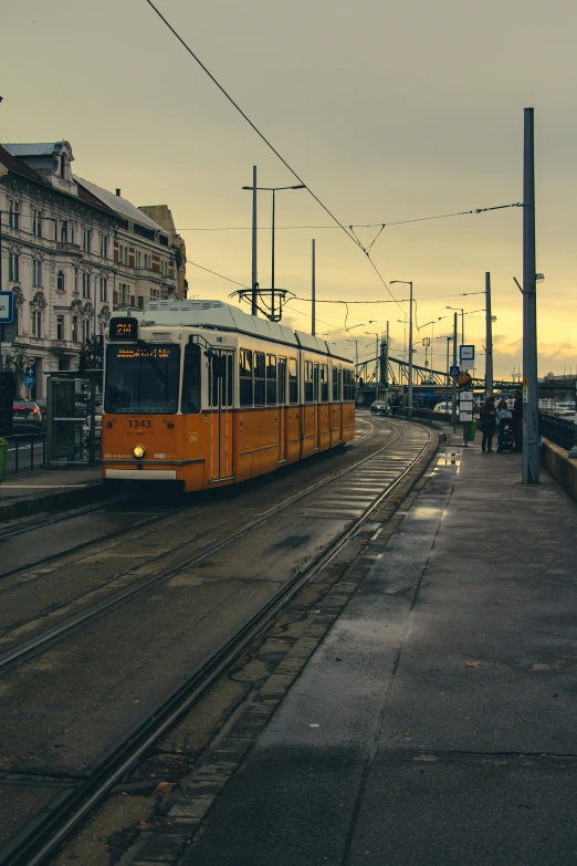 a long train sits on a track near a busy street