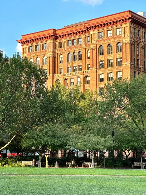 a group of buildings with trees and a grassy field