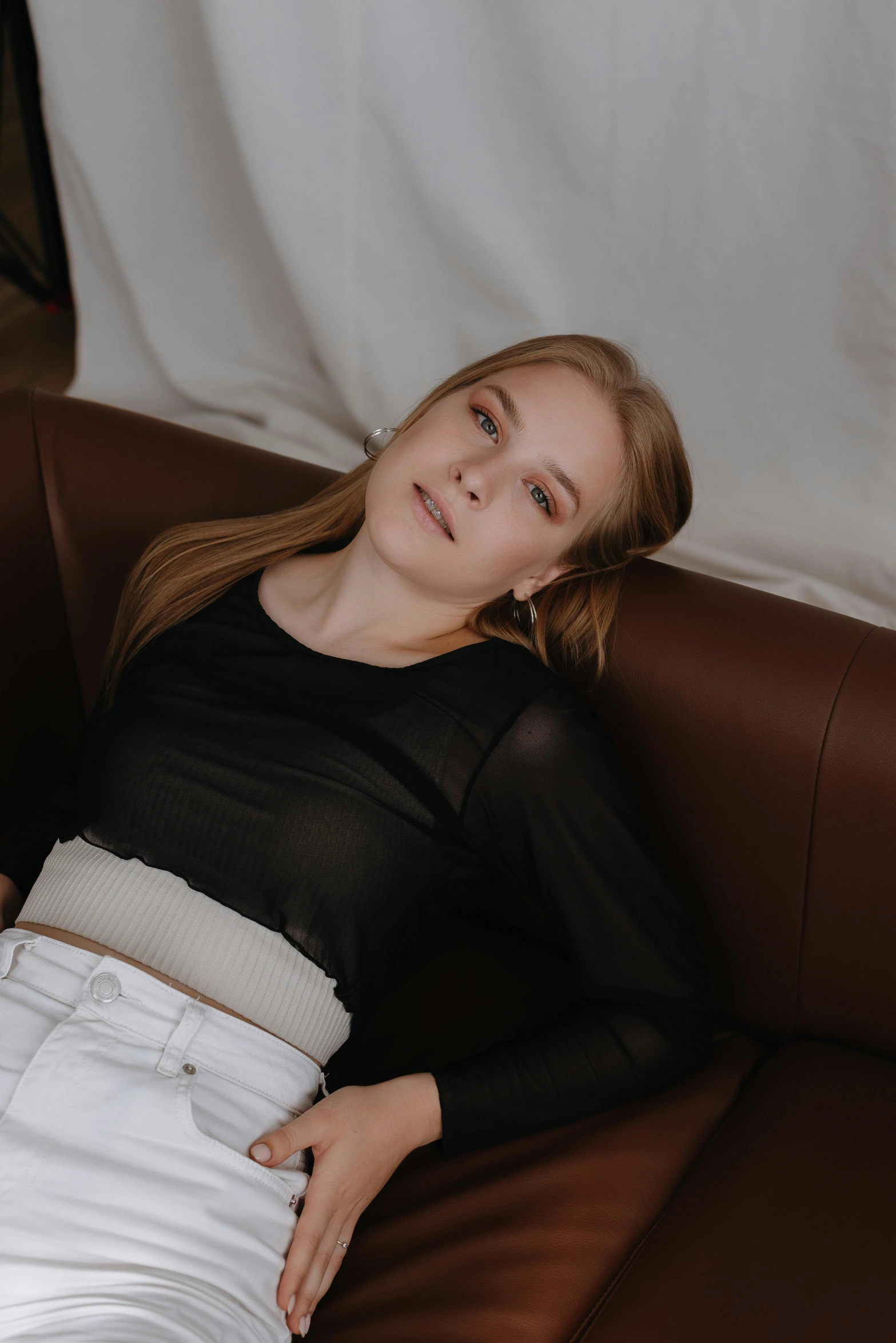 a woman that is sitting down and wearing white pants