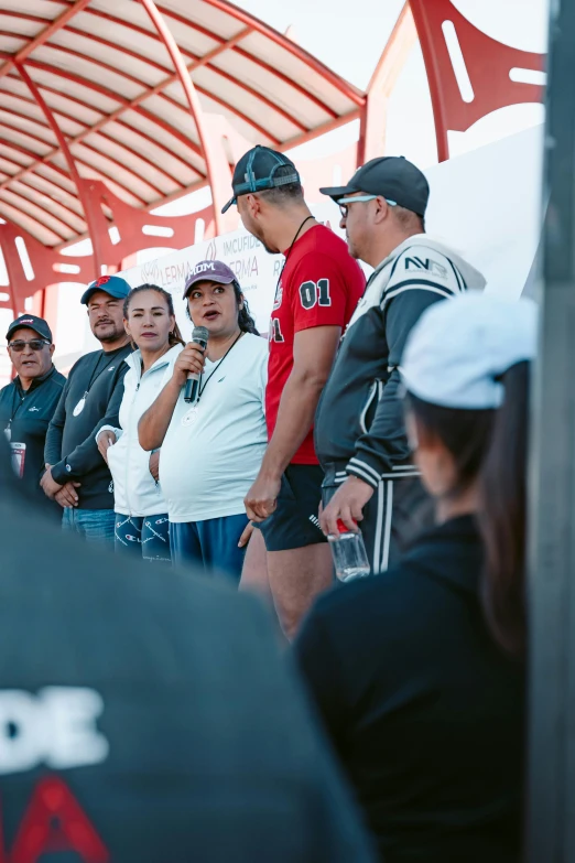 a group of people standing under a metal umbrella