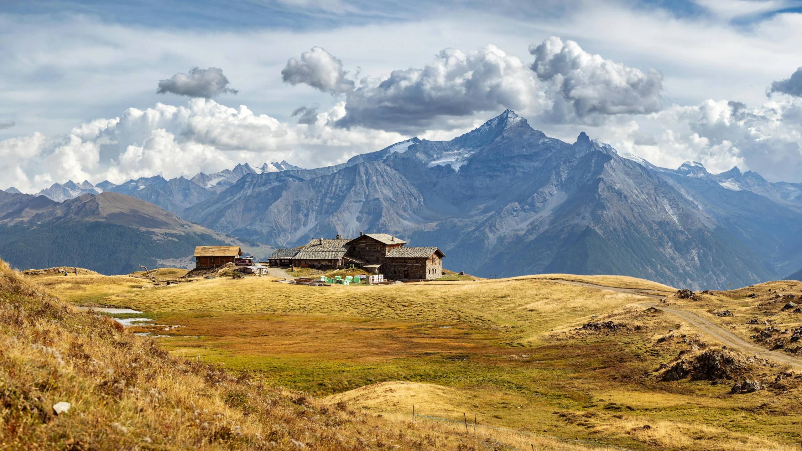 a house sits on the edge of the grassy field