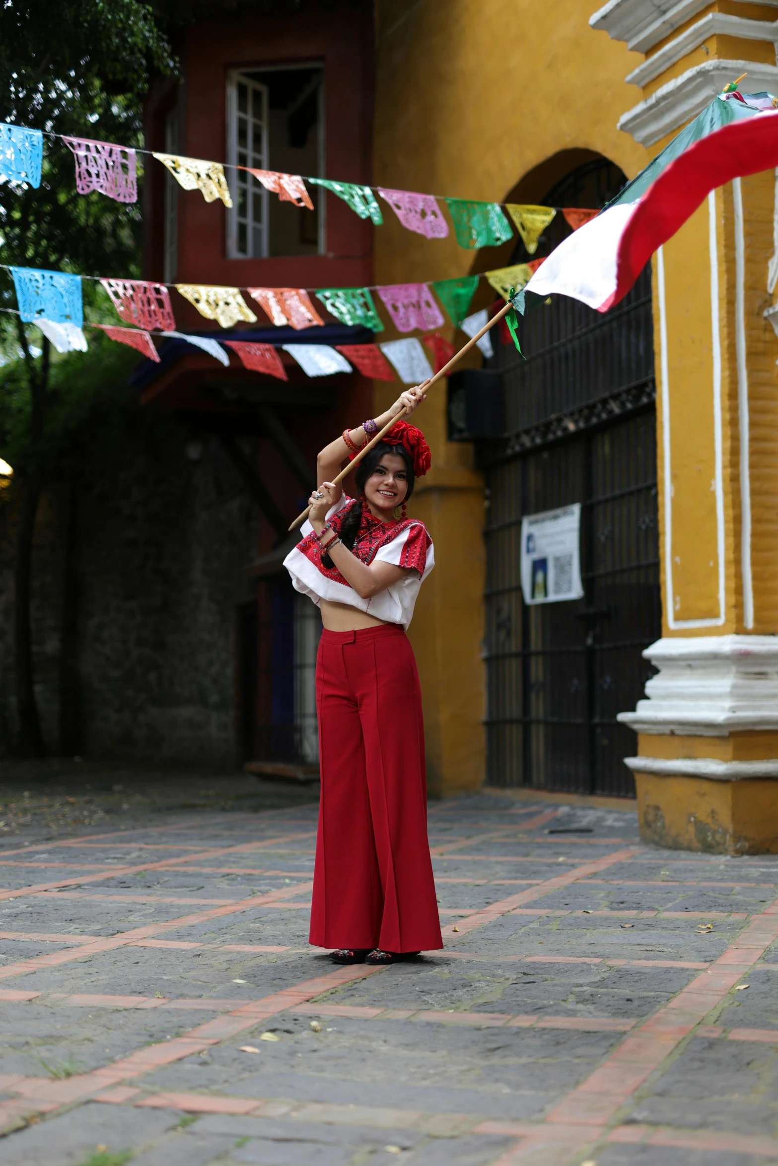 a woman holding up a kite next to colorful streamers