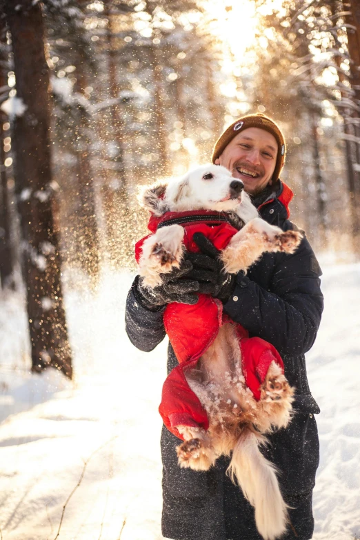 a person holding a dog in the snow