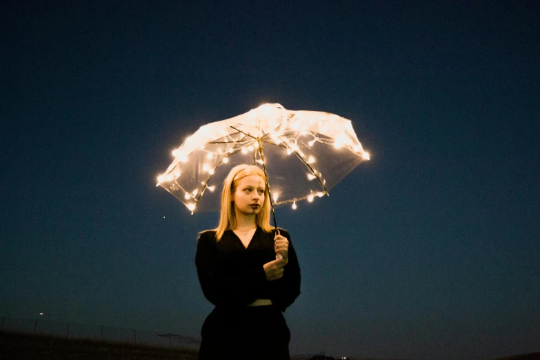 the woman is holding a light up umbrella