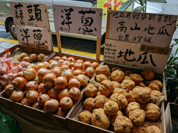 various kinds of asian fruit at an outdoor food stand