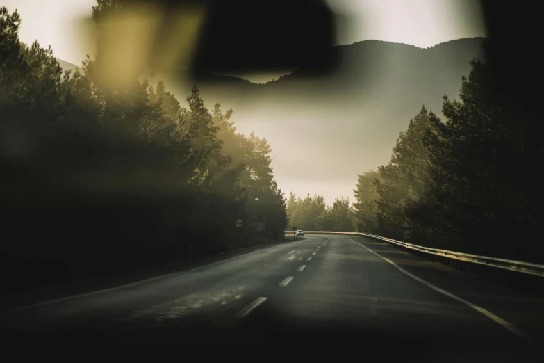 a view of an empty highway near several trees