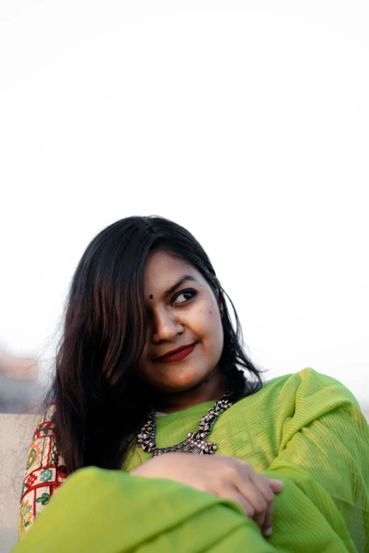 smiling woman wearing sari holding a green cloth