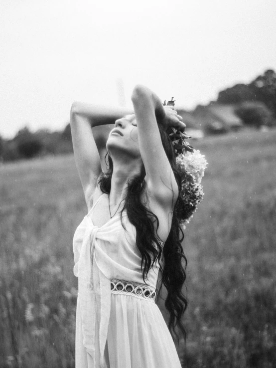 a woman in a dress and white hat standing on a field