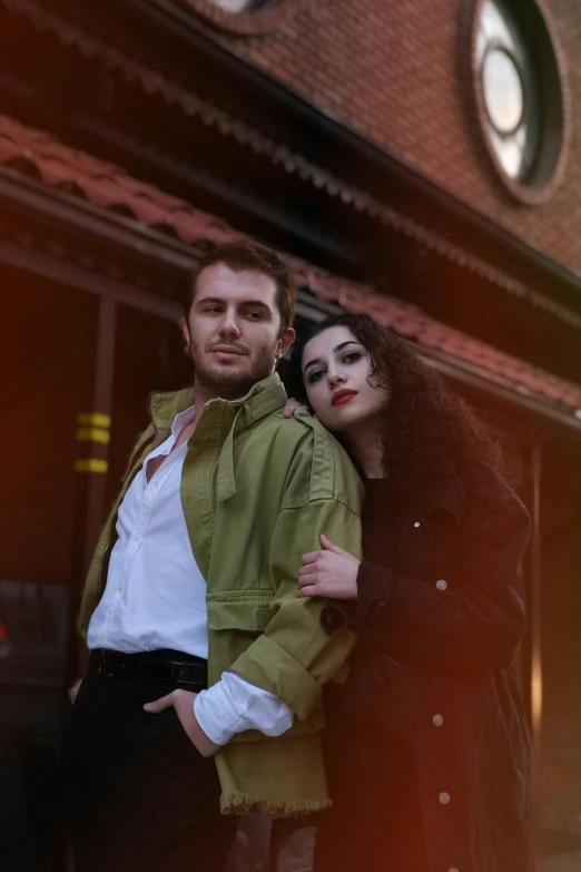 a man and woman standing in front of a building