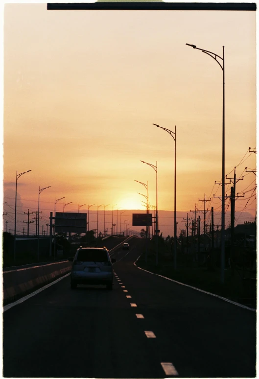 a car is driving down the road with traffic lights on the sides