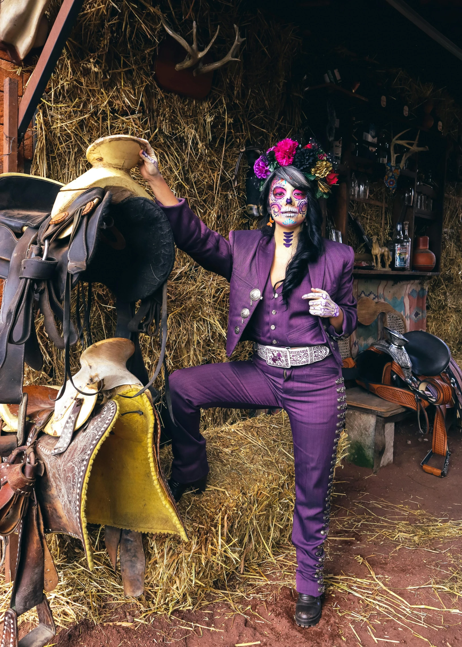 a woman in a mardi gras outfit standing next to some saddle