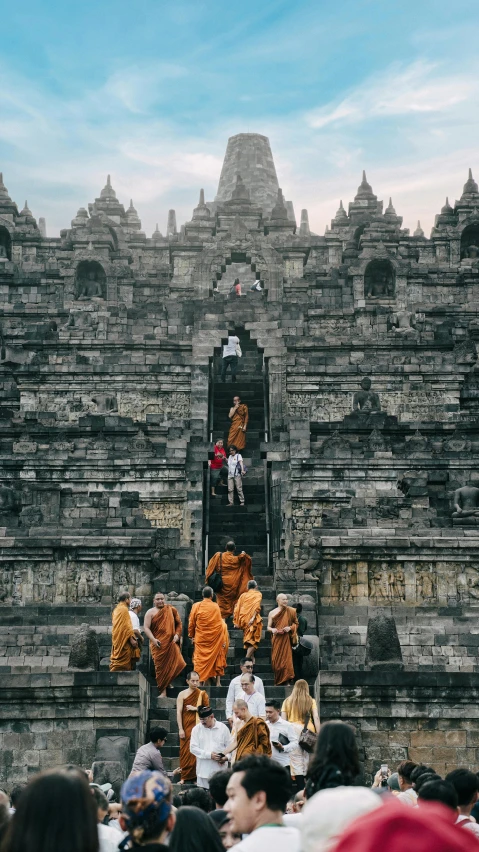 people standing on steps going to some building made of stone