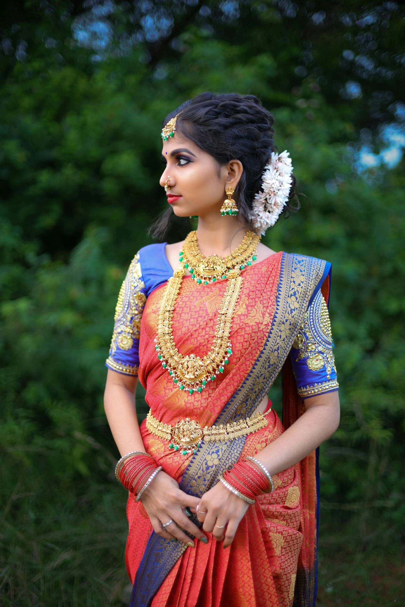 a woman dressed in red and gold dress and necklace