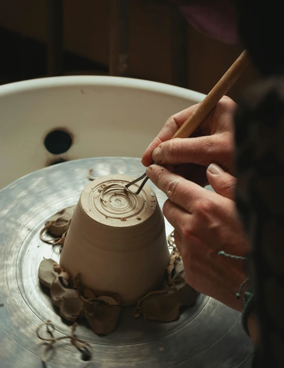 a close up of a person creating soing out of clay