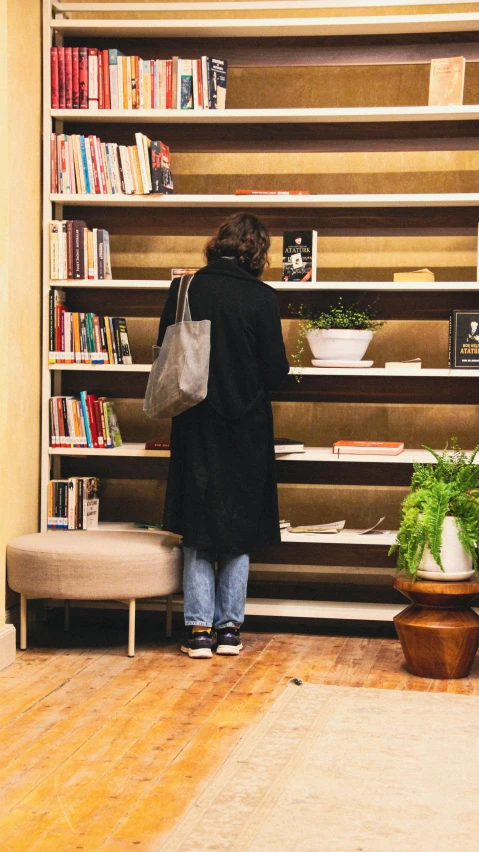 a person stands at the end of a long book shelf