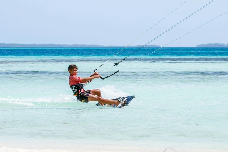 a person is windsurfing in the ocean near a beach