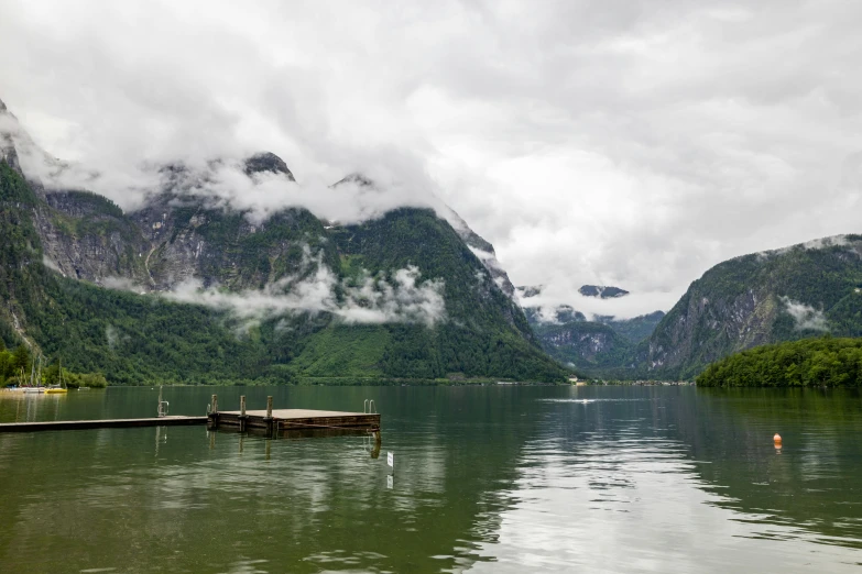 a boat sitting on top of a lake under mountains