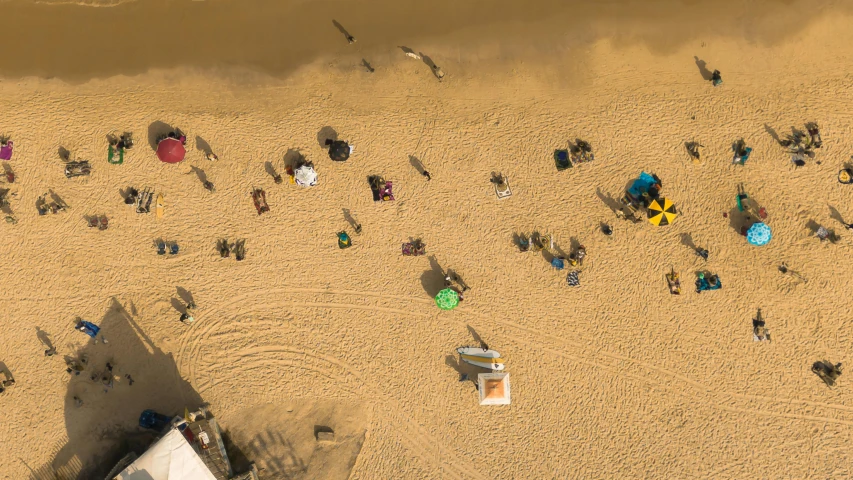 aerial view of beach with many people and a picnic area