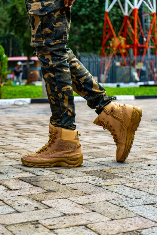 a close up view of a man wearing camo pants and brown shoes