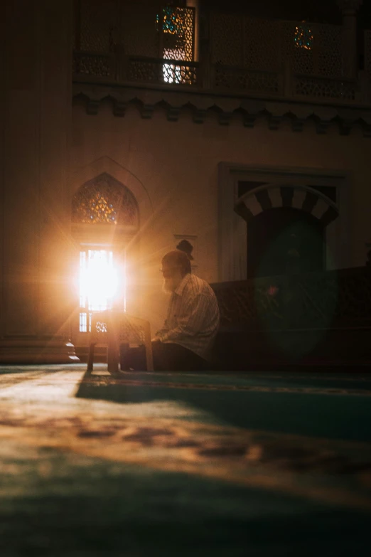 two men sitting on the ground with a light on