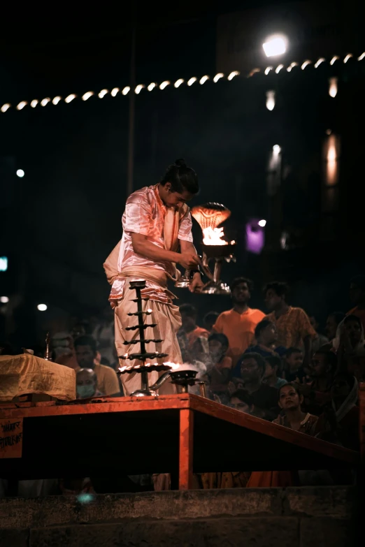 a man is making soing while standing on a platform in the dark