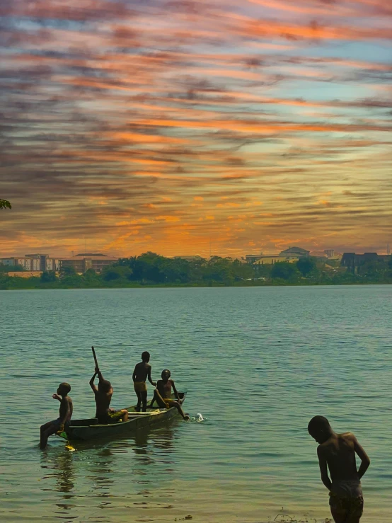 people on a canoe with a person standing in the water watching