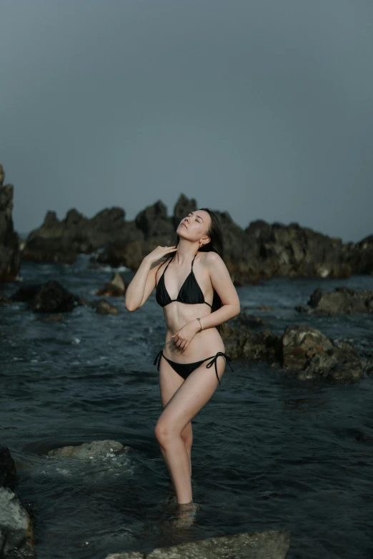 a woman in a bikini stands in the water