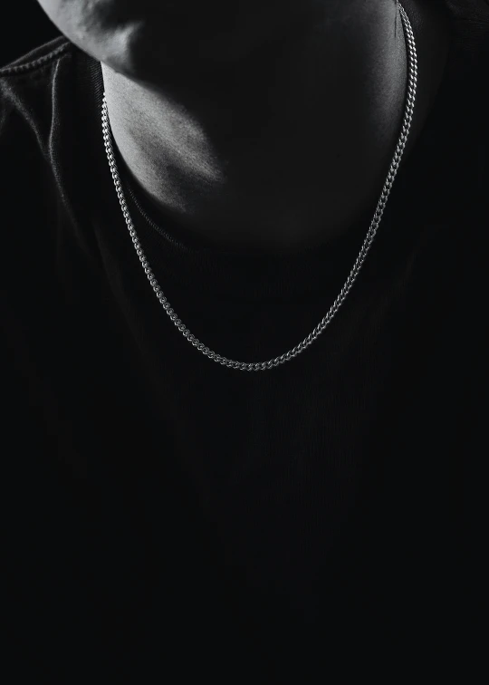a person wearing a necklace with a chain
